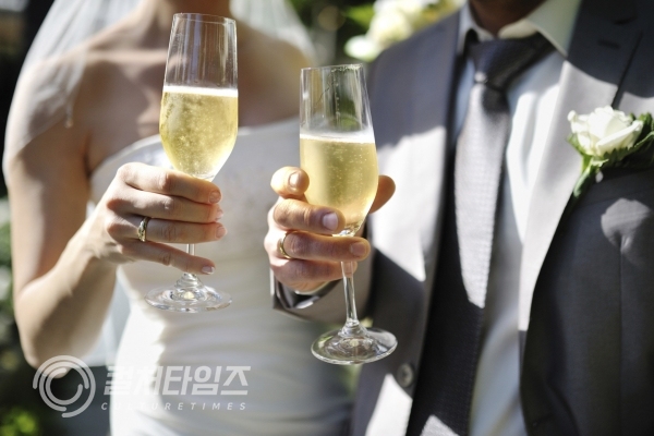결혼식에서 신랑, 신부가 샴페인으로 축배를 들고 있다. (출처_WTOP)